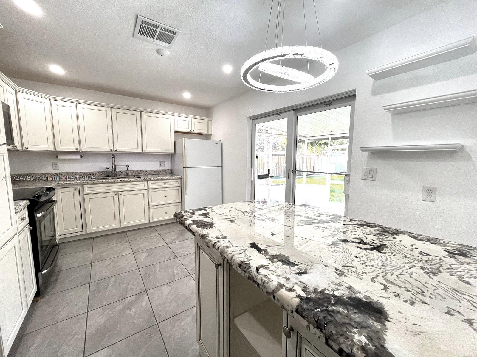 1600 North 56th Avenue Hollywood, FL 33021 - Photo 7 of 25 a kitchen with a stove a sink a refrigerator and cabinets