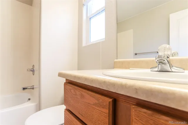a bathroom with a granite countertop sink a toilet and bathtub