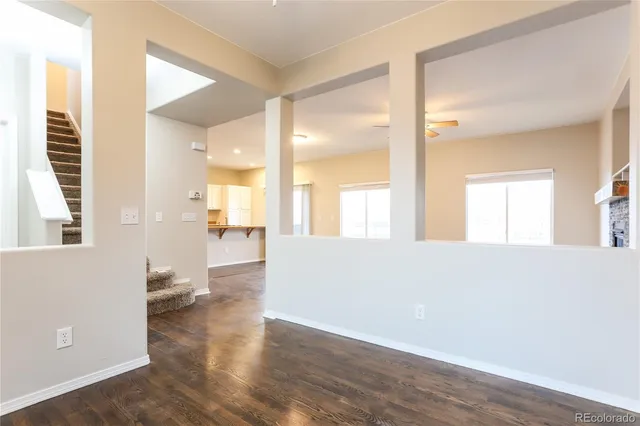 a view of a hallway with wooden floor and a bathroom