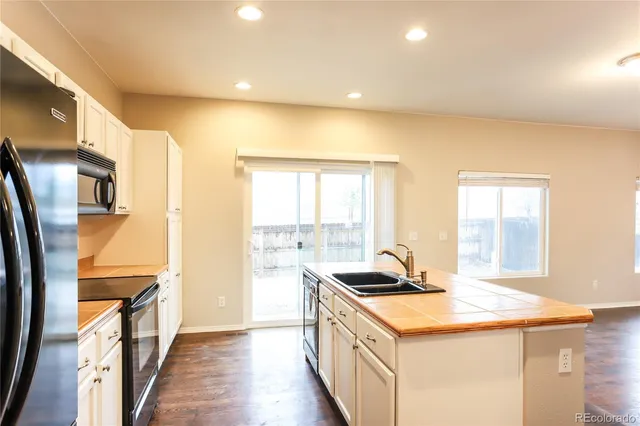 a kitchen with stainless steel appliances granite countertop a sink and a refrigerator