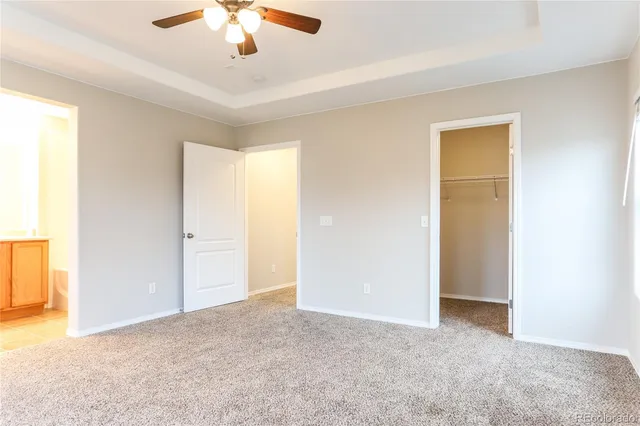 a view of an empty room with a chandelier fan