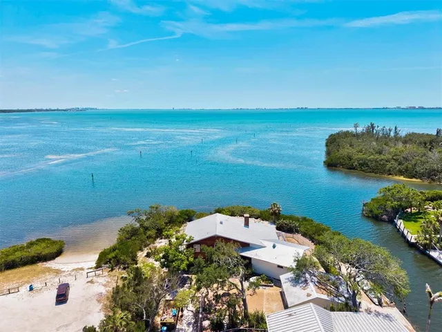 an aerial view of ocean with residential houses with outdoor space