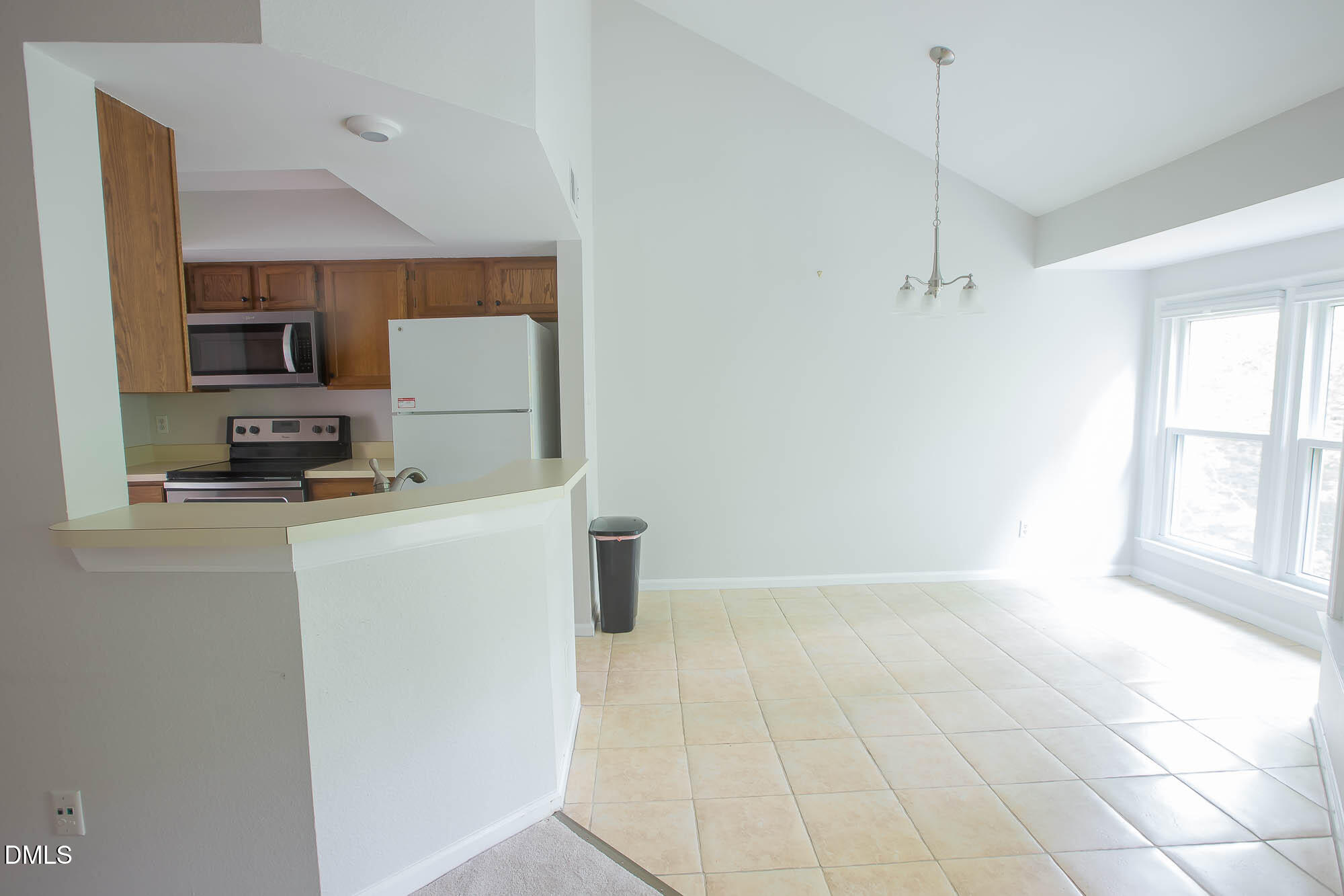 115 Abingdon Court, Unit 2B Cary, NC 27513 - Photo 3 of 9 a kitchen with a refrigerator a stove a microwave and a window