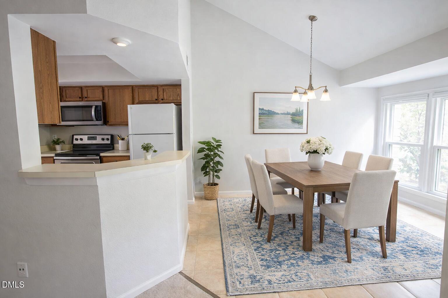 115 Abingdon Court, Unit 2B Cary, NC 27513 - Photo 3 of 9 a dining room with furniture a rug a potted plant and a chandelier