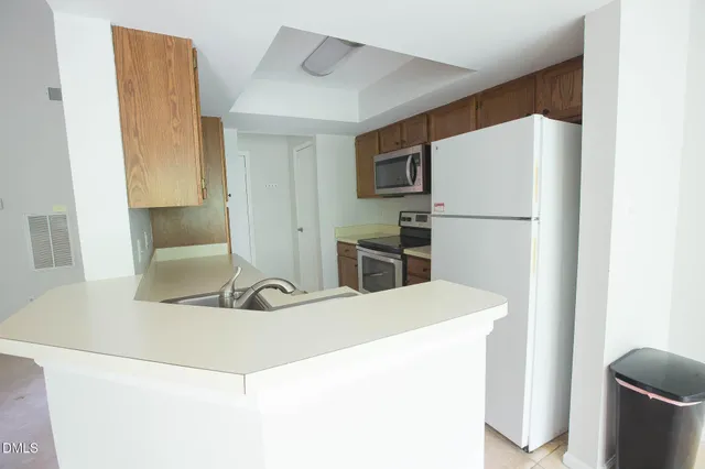 a room with a sink and a refrigerator