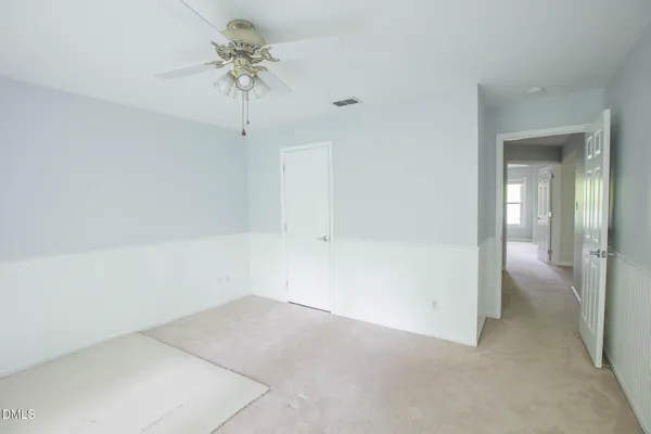 wooden floor in an empty room with a chandelier fan
