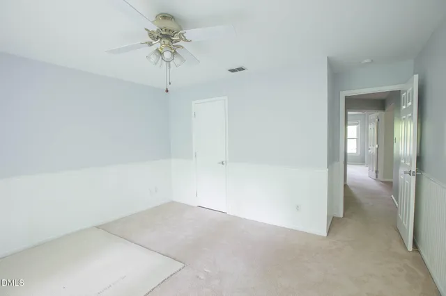 wooden floor in an empty room with a chandelier fan