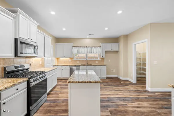 a kitchen with granite countertop a stove and a sink