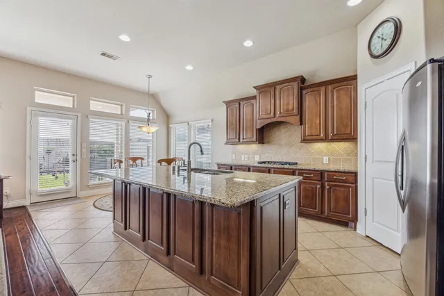 a kitchen with stainless steel appliances granite countertop a sink and a stove