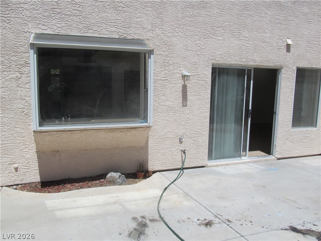 8701 Crescent Ridge Lane Las Vegas, NV 89134 - Photo 26 of 28 A window and sliding glass door offer seamless indoor-outdoor access to the concrete patio.
