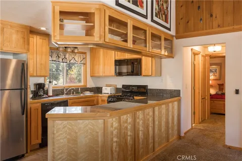 a kitchen with stainless steel appliances granite countertop a refrigerator a stove and a sink with cabinets