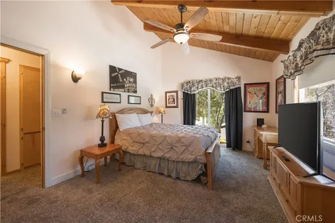 a bedroom with a bed and a flat tv screen on dresser