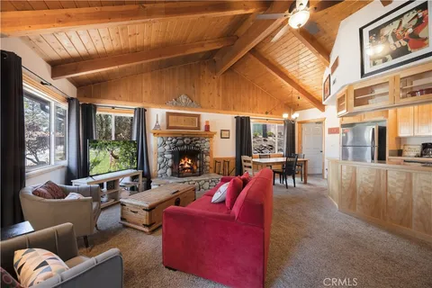 a living room with furniture a fireplace and a large window