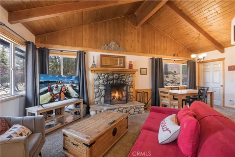 a living room with furniture a fireplace and a large window