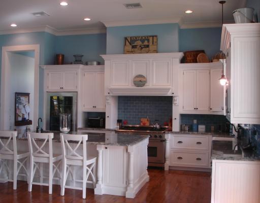5575 Pennock Point Road Jupiter, FL 33458 - Photo 4 of 16 a kitchen with stainless steel appliances granite countertop a stove top oven a sink a dining table and chairs with wooden floor