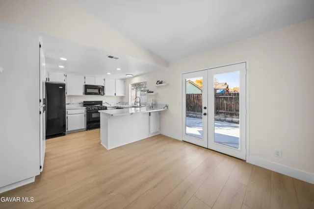 a view of kitchen with stainless steel appliances refrigerator stove microwave and cabinets