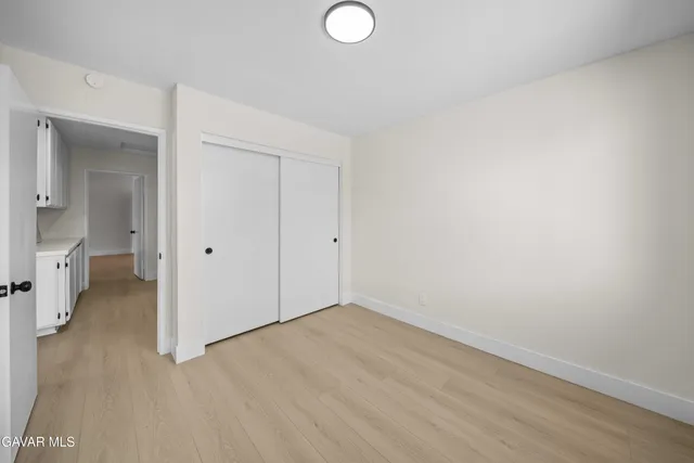 an empty room with windows and cabinet