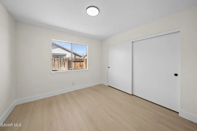 a view of a kitchen with wooden floor and cabinets