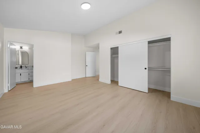 a bathroom with a double vanity sink a toilet and a mirror