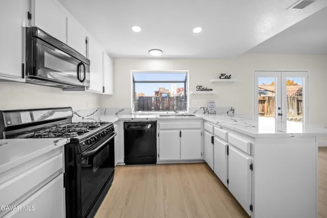 a kitchen with a stove a sink and a microwave