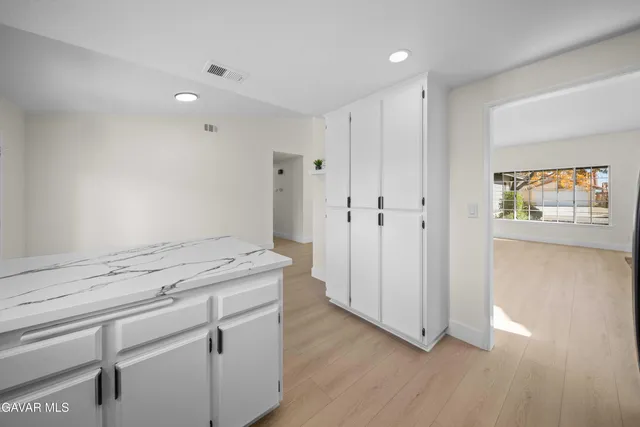 a kitchen with stainless steel appliances kitchen island granite countertop a sink refrigerator and cabinets