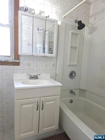 a bathroom with a granite countertop sink a toilet and shower