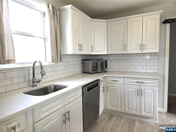 a kitchen with granite countertop white cabinets and white appliances
