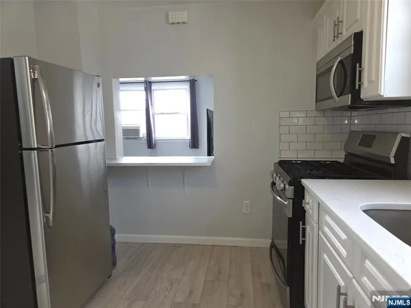 a kitchen with a refrigerator sink and cabinets