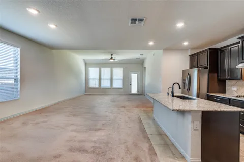 a large kitchen with kitchen island a sink stainless steel appliances and a counter top space