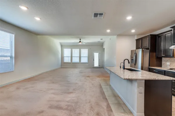 a large kitchen with kitchen island a sink stainless steel appliances and a counter top space