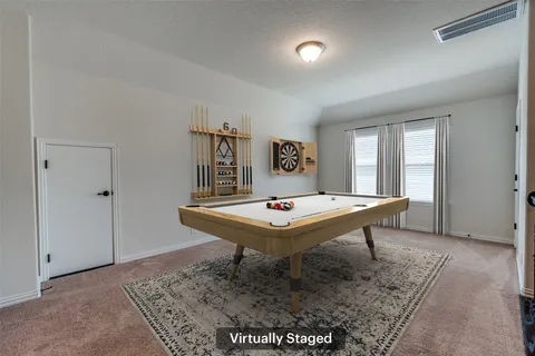 a room with pool table and windows