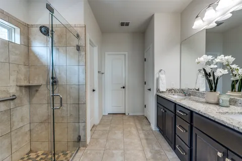 a bathroom with a granite countertop sink a mirror and a shower