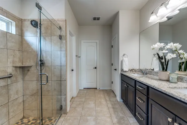 a bathroom with a granite countertop sink a mirror and a shower