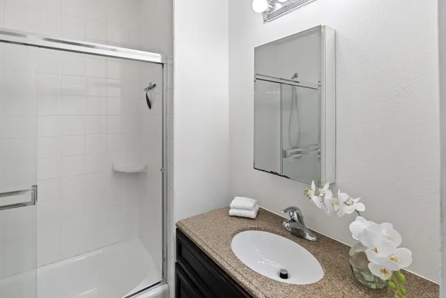 a bathroom with a granite countertop sink toilet and shower