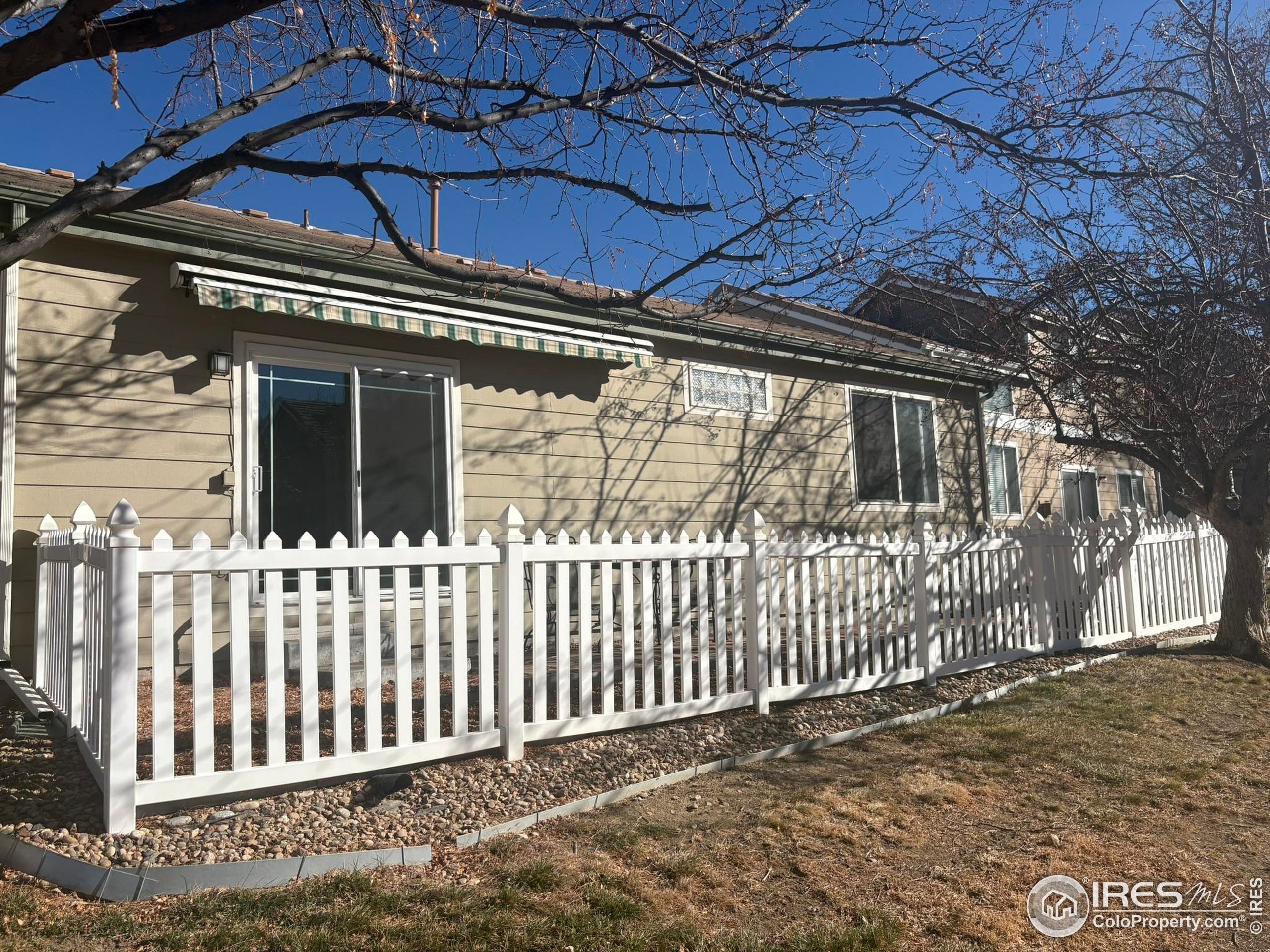 13963 Cook Street Thornton, CO 80602 - Photo 17 of 18 a view of a house with a small yard and wooden fence