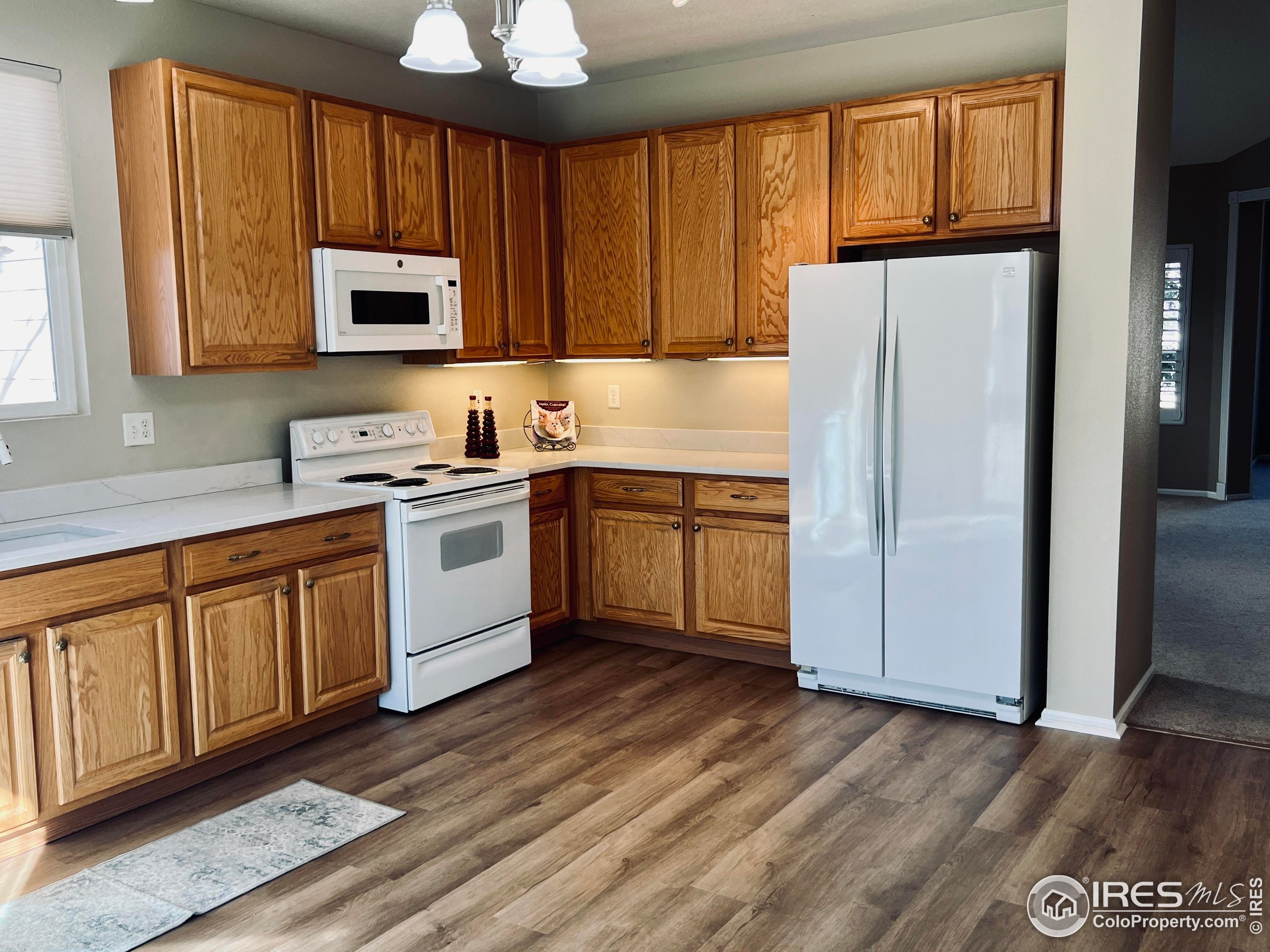 13963 Cook Street Thornton, CO 80602 - Photo 8 of 18 a kitchen with stainless steel appliances granite countertop a refrigerator a sink dishwasher and wooden cabinets with wooden floor