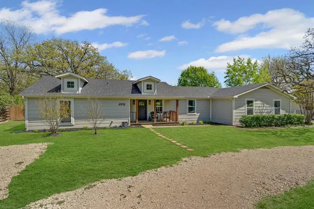 a front view of a house with a garden and plants