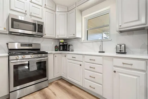 a kitchen with cabinets stainless steel appliances and a sink