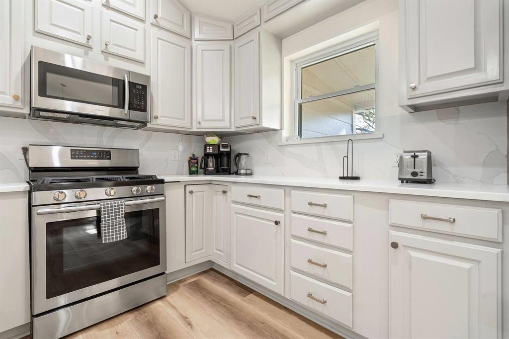 4918 Farris Road Denton, TX 76208 - Photo 11 of 28 a kitchen with cabinets stainless steel appliances and a sink