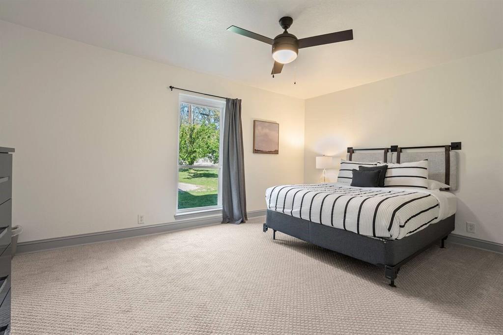 4918 Farris Road Denton, TX 76208 - Photo 18 of 28 a bedroom with a large bed and a ceiling fan