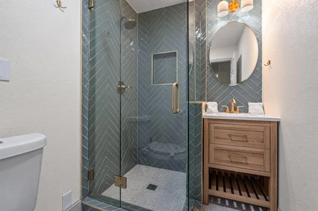 a bathroom with a shower a sink and mirror