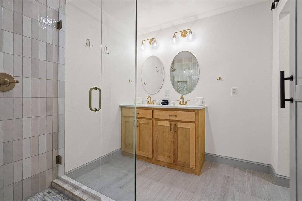 4918 Farris Road Denton, TX 76208 - Photo 22 of 28 a bathroom with a granite countertop sink a mirror and shower