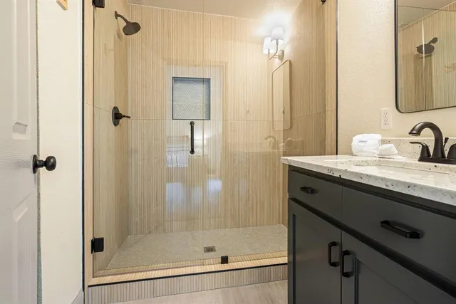 a bathroom with a shower sink and mirror