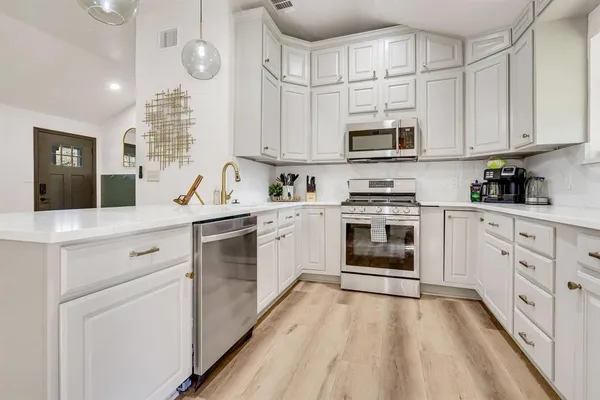a kitchen with stainless steel appliances a stove sink and cabinets