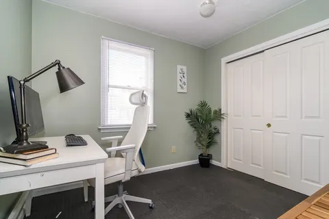 a view of a workspace with furniture and a window