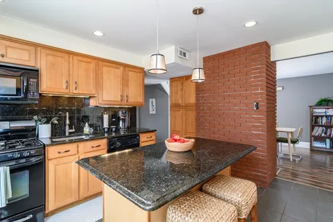 a kitchen with stainless steel appliances granite countertop a sink refrigerator and cabinets