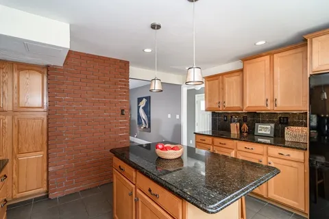 a kitchen with stainless steel appliances granite countertop a sink a microwave and wooden cabinets