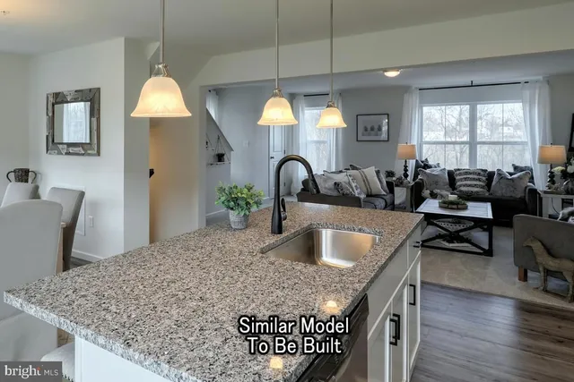 a kitchen with granite countertop a table chairs stove and wooden floor
