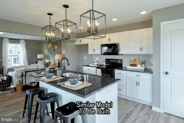 a kitchen with stainless steel appliances a dining table chairs stove and cabinets