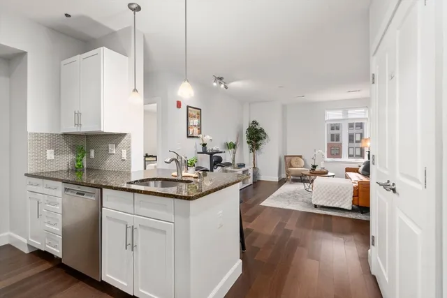 a kitchen with white cabinets and sink